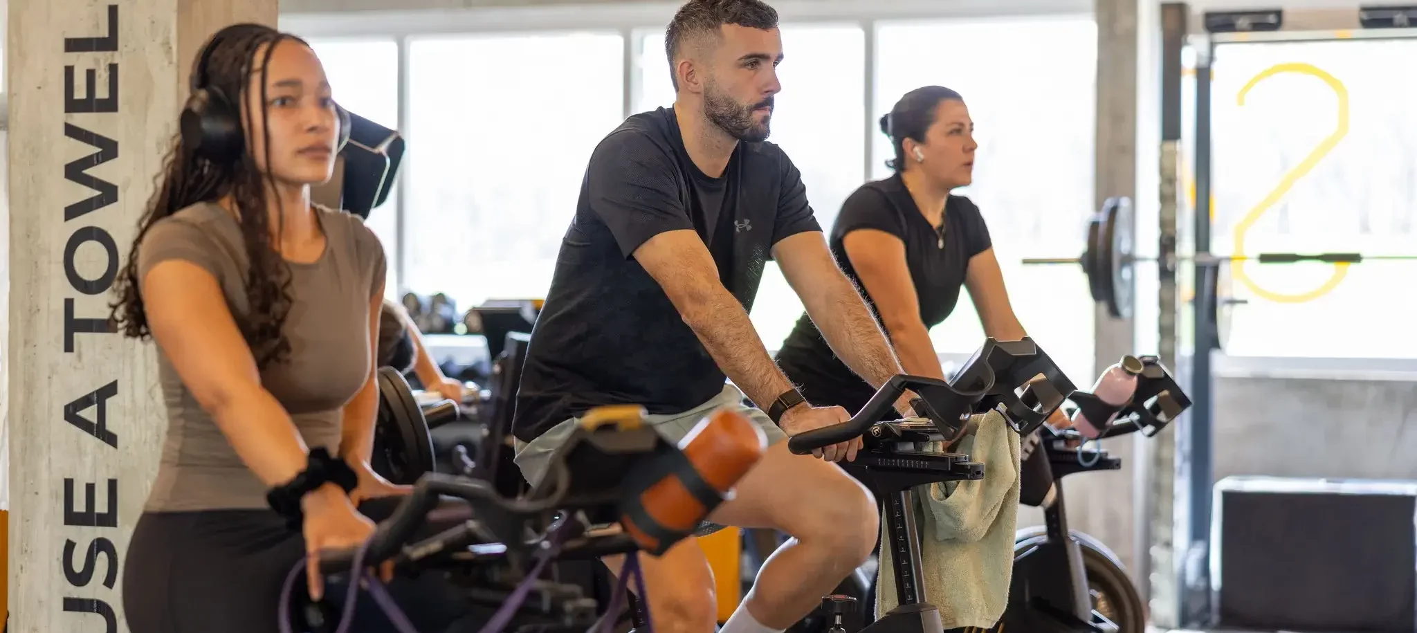 Des participants à une formation FitspRO réalisent un exercice de cardio sur vélos indoor - FITSPRO